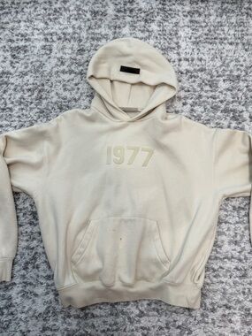 essentials 1977 Graphic Hoodie in Cream, stains on pocket